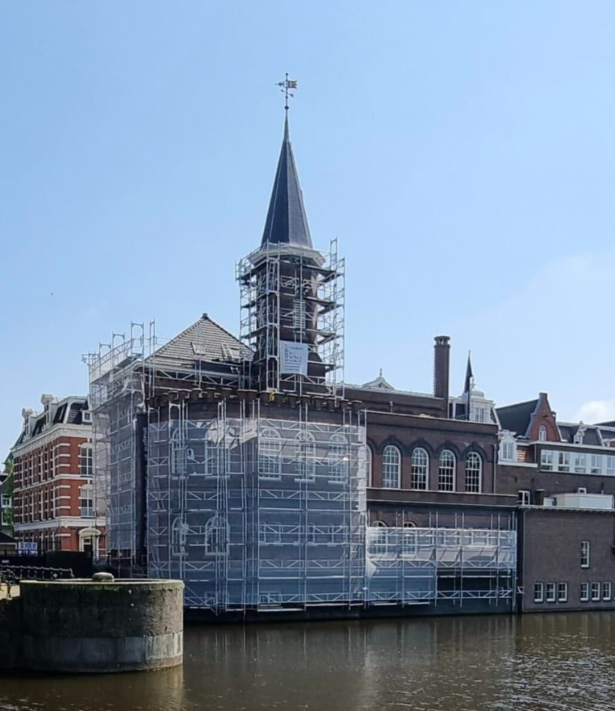 Steigerbouw aan een historisch gebouw langs het water